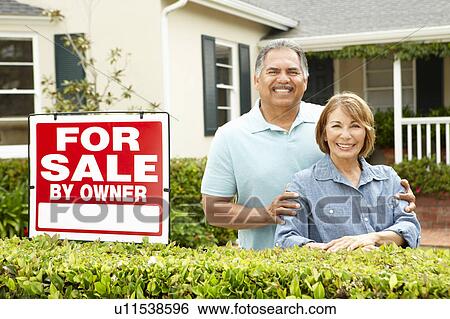 Stock Photograph - Senior Hispanic couple selling house. Fotosearch
