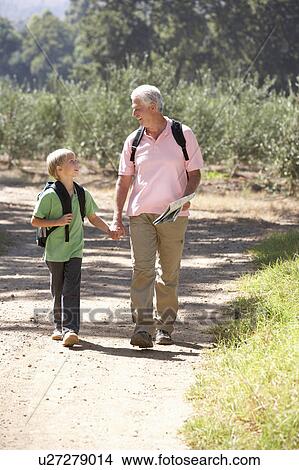 Picture - Senior man and grandson on country walk. Fotosearch