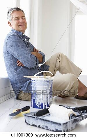 Stock Photo - Senior man decorating house. Fotosearch
