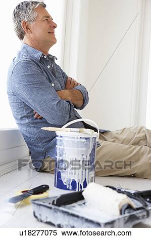 Stock Photography - Senior man decorating house. Fotosearch