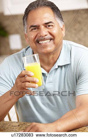 Stock Image - Senior man drinking orange juice. Fotosearch