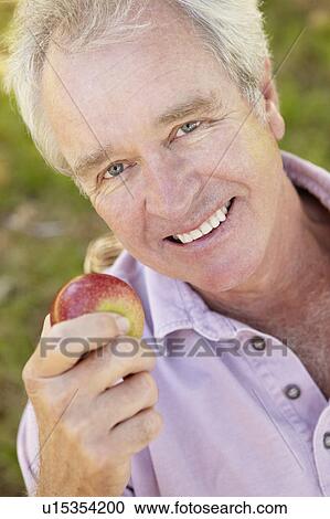 Stock Image - Senior man eating apple. Fotosearch