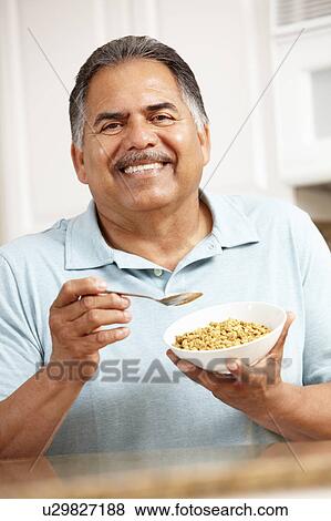 Senior man eating cereal View Large Photo Image Stock Photo - Senior man eating cereal. Fotosearch