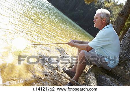 Senior man fishing at lake View Large Photo Image Stock Image - Senior man fishing at lake. Fotosearch