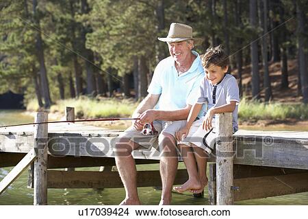 Picture - Senior man fishing with grandson. Fotosearch