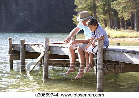Senior man fishing with grandson View Large Photo Image Picture - Senior man fishing with grandson. Fotosearch