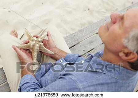 Senior man holding starfish View Large Photo Image Stock Photo - Senior man holding starfish. Fotosearch