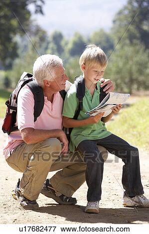 Senior man reading map with grandson on country walk View Large Photo Image Stock Photo - Senior man reading map with grandson on country walk. Fotosearch