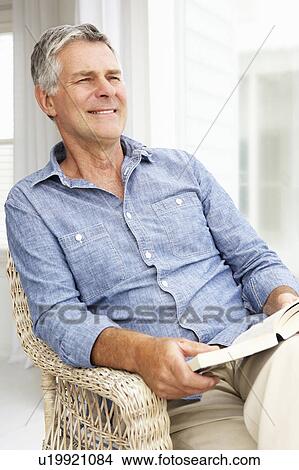 Senior man relaxing at home with a book View Large Photo Image Picture - Senior man relaxing at home with a book. Fotosearch