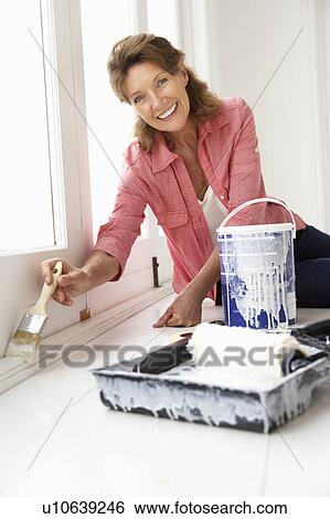 Stock Photograph - Senior woman decorating house. Fotosearch