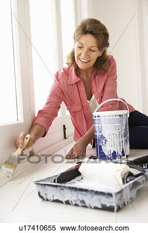 Stock Photography - Senior woman decorating house. Fotosearch