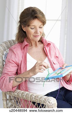 Picture - Senior woman doing cross stitch. Fotosearch