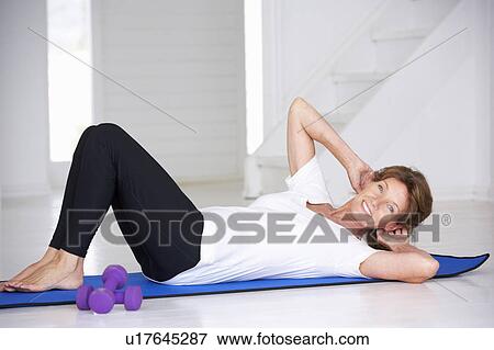 Stock Photo - Senior woman doing curl-ups. Fotosearch