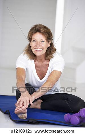 Stock Photography - Senior woman exercising at home. Fotosearch