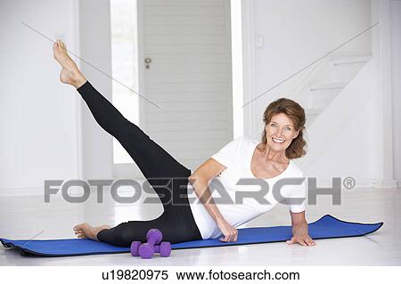 Stock Photography - Senior woman exercising in home gym. Fotosearch