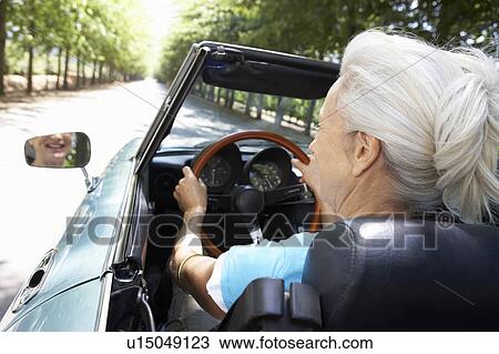 Stock Image - Senior woman in sports car. Fotosearch