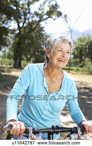 Stock Photo - Senior woman on country bike ride. Fotosearch