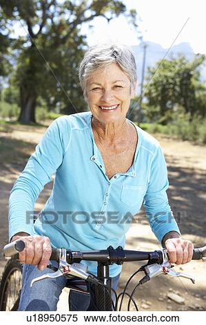 Stock Photography - Senior woman on country bike ride. Fotosearch