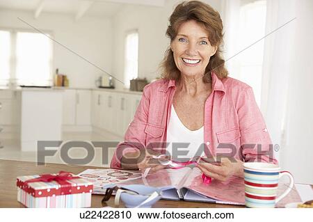Stock Image - Senior woman scrapbooking. Fotosearch