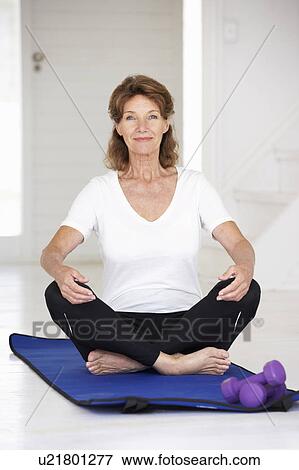 Stock Photo - Senior woman sitting in lotus position. Fotosearch