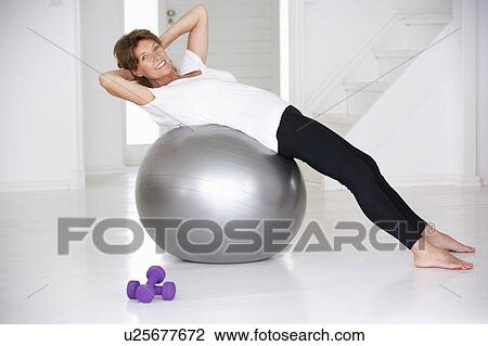 Stock Image - Senior woman using gym ball. Fotosearch