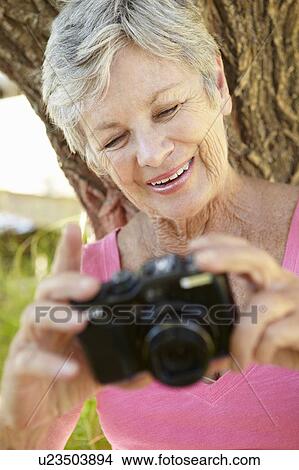 Picture - Senior woman with camera. Fotosearch