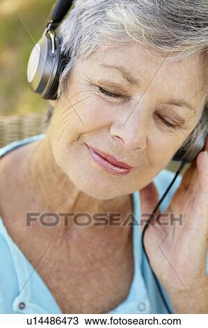 Stock Image - Senior woman with headphone. Fotosearch