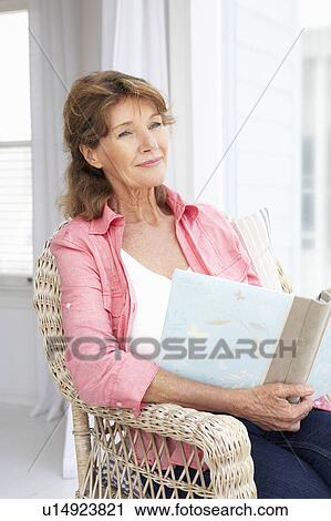 Stock Image - Senior woman with photo album. Fotosearch