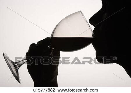 Stock Image - Silhouette man drinking red wine. Fotosearch