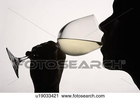 Stock Image - Silhouette man drinking red wine. Fotosearch