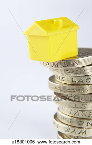Stock Photograph - Small model house and coins. Fotosearch