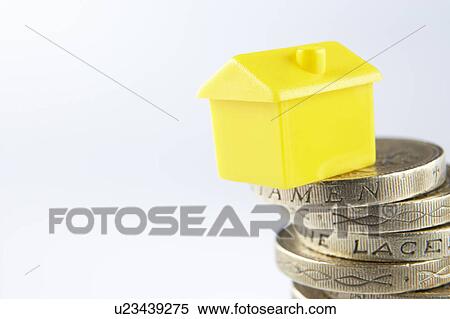 Stock Photography - Small model house and coins. Fotosearch