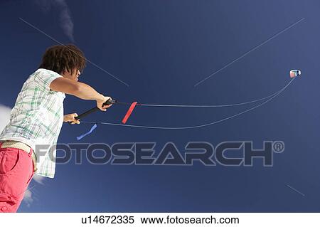 Stock Photography - Teenage boy flying a kite. Fotosearch