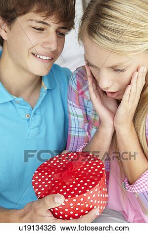 Stock Photograph - Teenage boy giving gift to girl. Fotosearch
