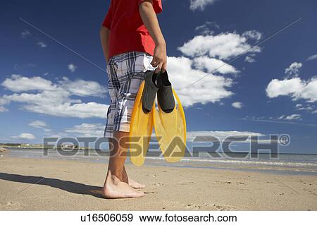 Stock Photo - Teenage boy on beach with flippers. Fotosearch