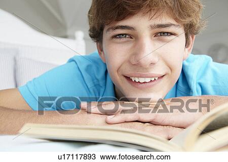 Stock Image - Teenage boy reading a book. Fotosearch