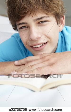 Teenage boy reading a book View Large Photo Image Stock Photograph - Teenage boy reading a book. Fotosearch
