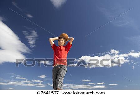 Stock Photo - Teenage boy throwing football. Fotosearch