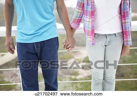 Stock Photo - Teenage girl and boy holding hands. Fotosearch
