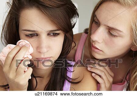 Picture - Teenage girl comforting tearful friend. Fotosearch