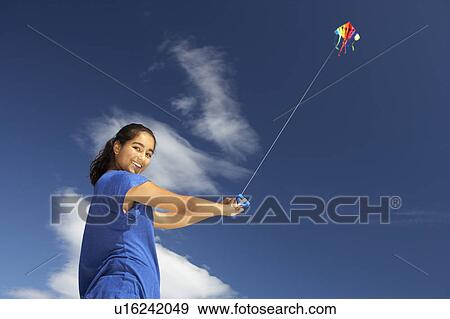 Teenage girl flying a kite View Large Photo Image Stock Photo - Teenage girl flying a kite. Fotosearch
