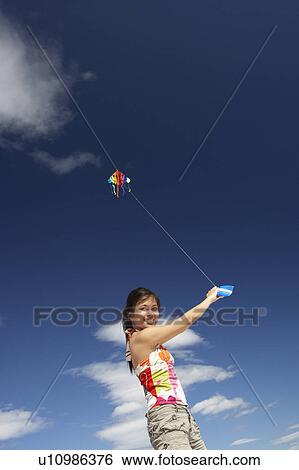 Teenage girl flying a kite View Large Photo Image Stock Photograph - Teenage girl flying a kite. Fotosearch