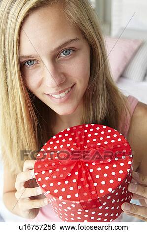 Stock Photograph - Teenage girl holding gift box. Fotosearch