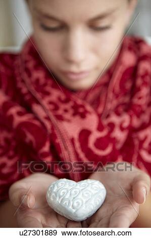 Stock Photo - Teenage girl holding silver heart. Fotosearch