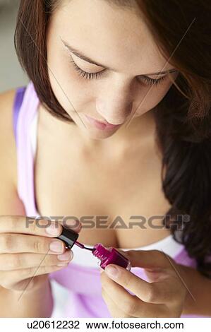Stock Image - Teenage girl painting nails. Fotosearch