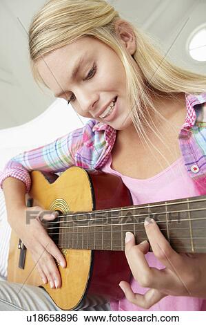 Stock Photograph - Teenage girl playing acoustic guitar. Fotosearch