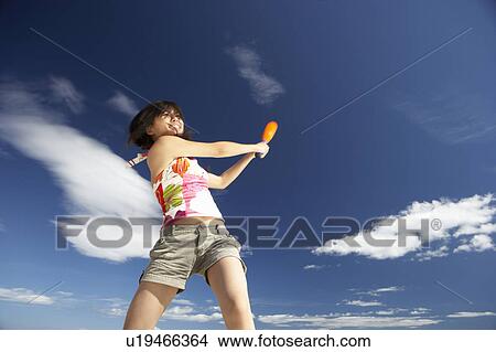 Picture - Teenage girl playing baseball on beach. Fotosearch