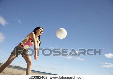 Stock Photo - Teenage girl playing beach volleyball. Fotosearch