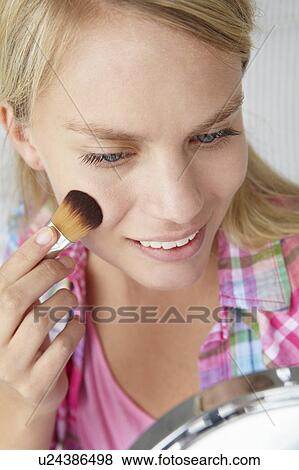 Stock Photo - Teenage girl putting on make-up. Fotosearch