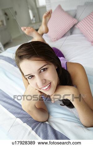 Teenage girl relaxing on bed View Large Photo Image Stock Photo - Teenage girl relaxing on bed. Fotosearch
